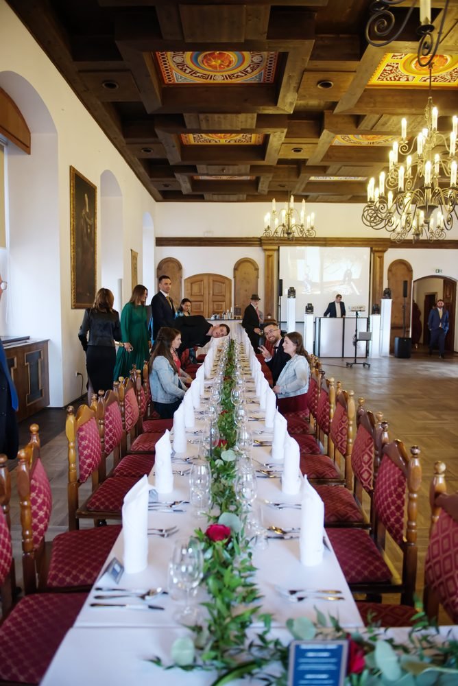 Long banquet table set for the wedding reception in a historic hall